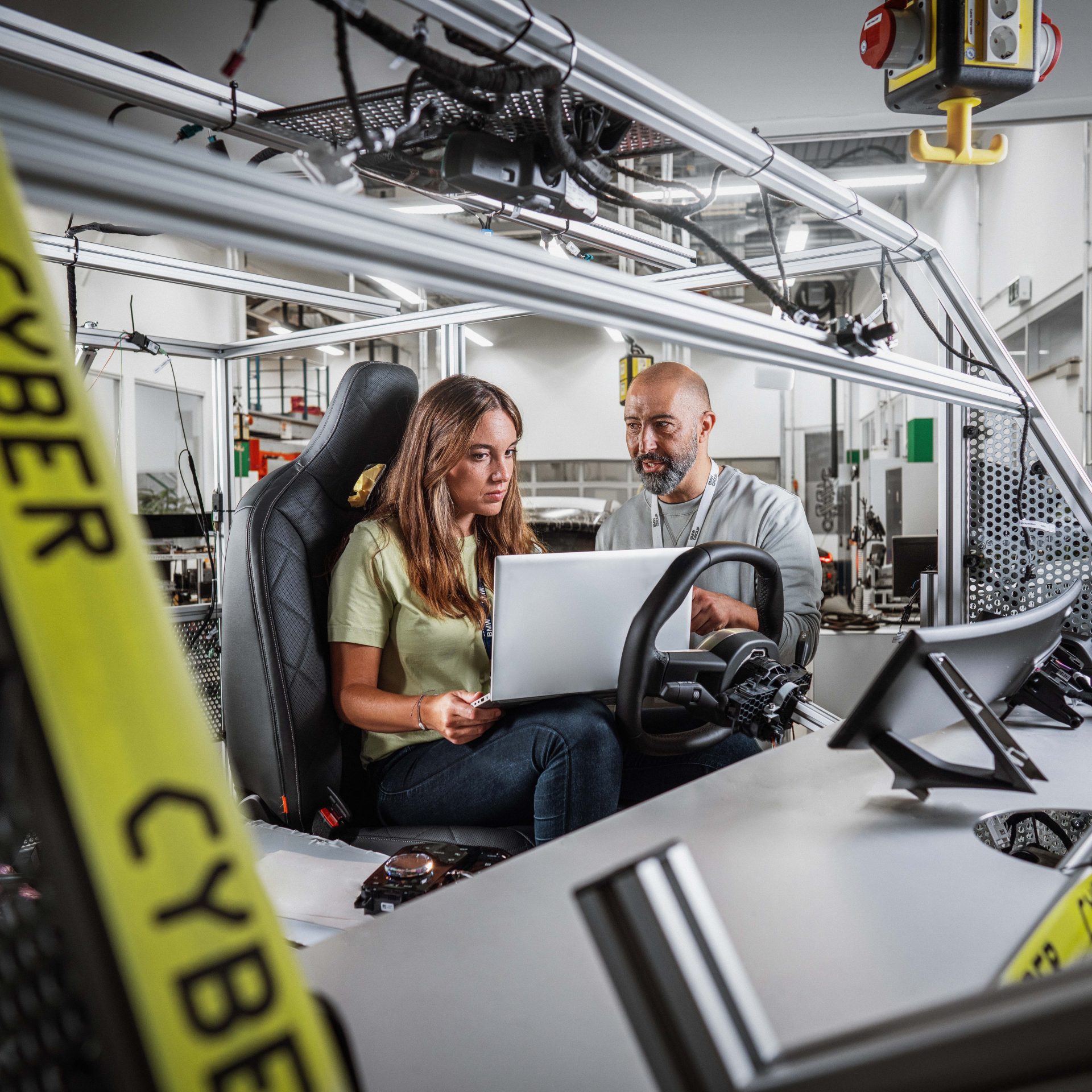Das Bild zeigt zwei BMW Mitarbeiter bei der Arbeit in einem IT-Labor..