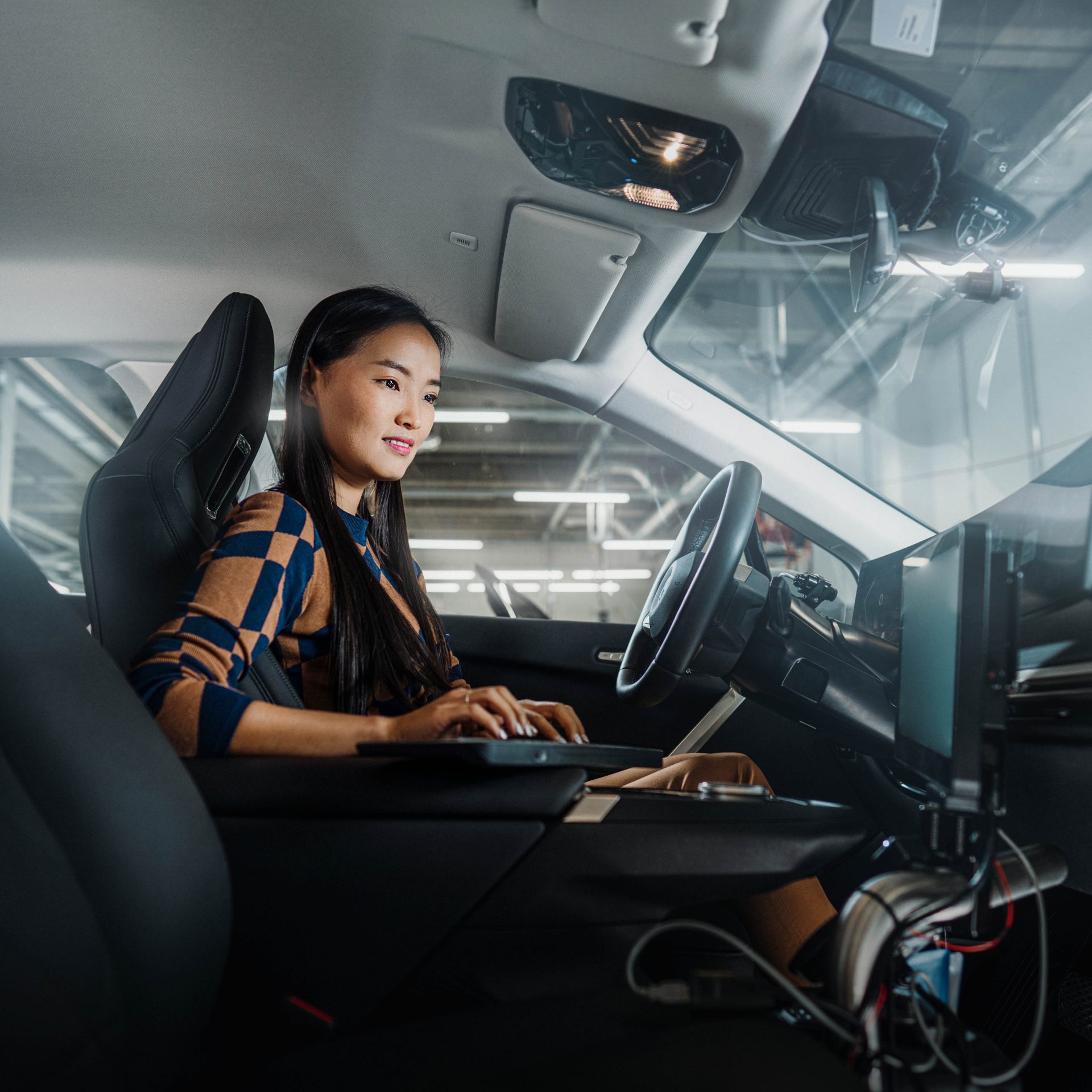Das Bild zeigt eine BMW Mitarbeiterin bei der Auswertung von Daten im Fahrzeug.