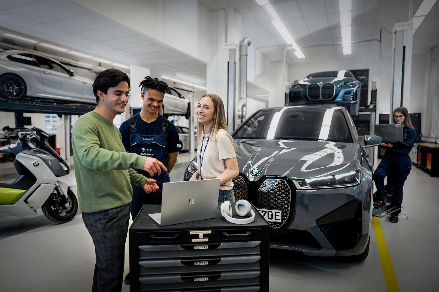 A group of apprentices are having a chat in front of a car at BMW Welt Munich
