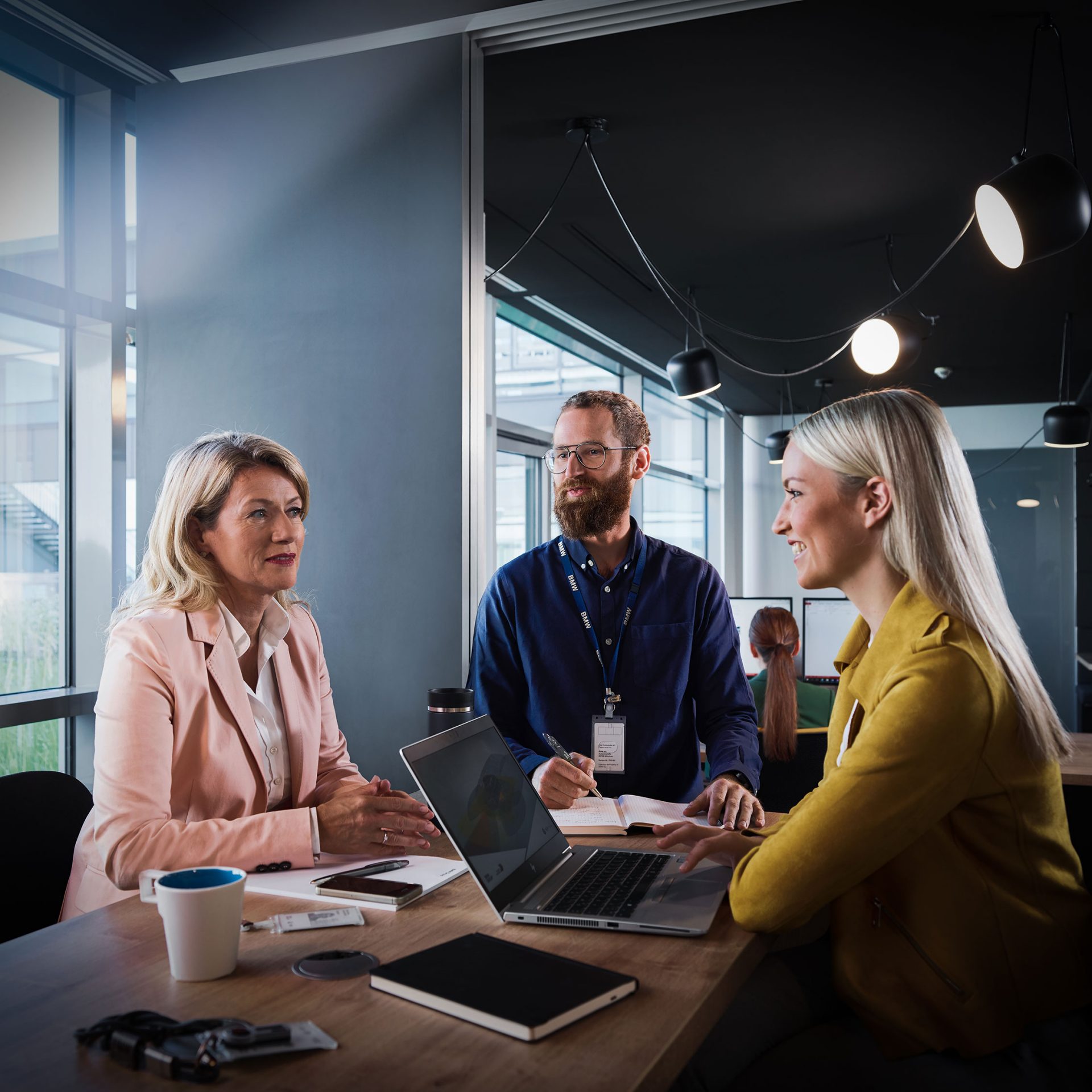 Three BMW employees are having a chat in the office.