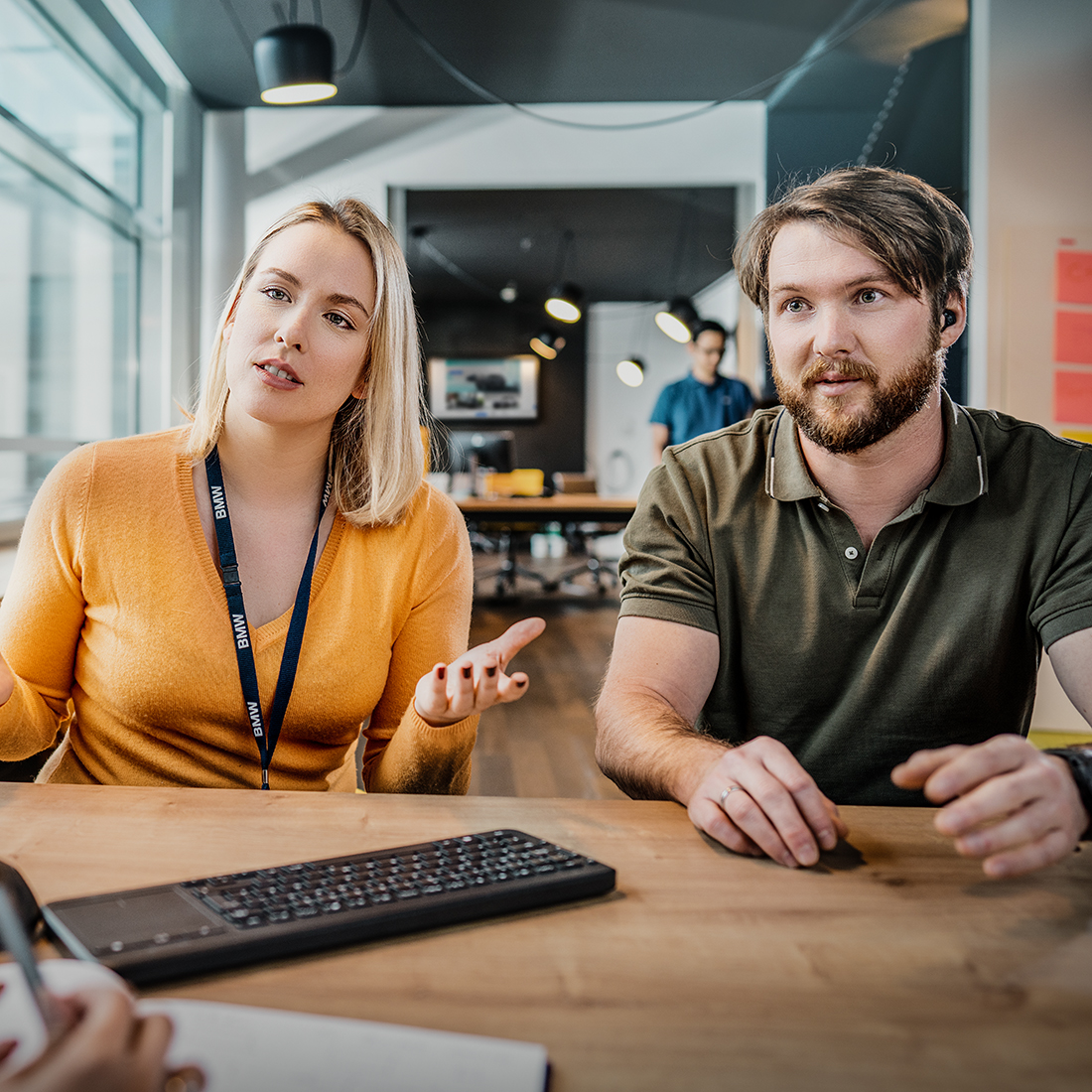 This photo shows three participants of the BMW graduate trainee program speaking to each other.