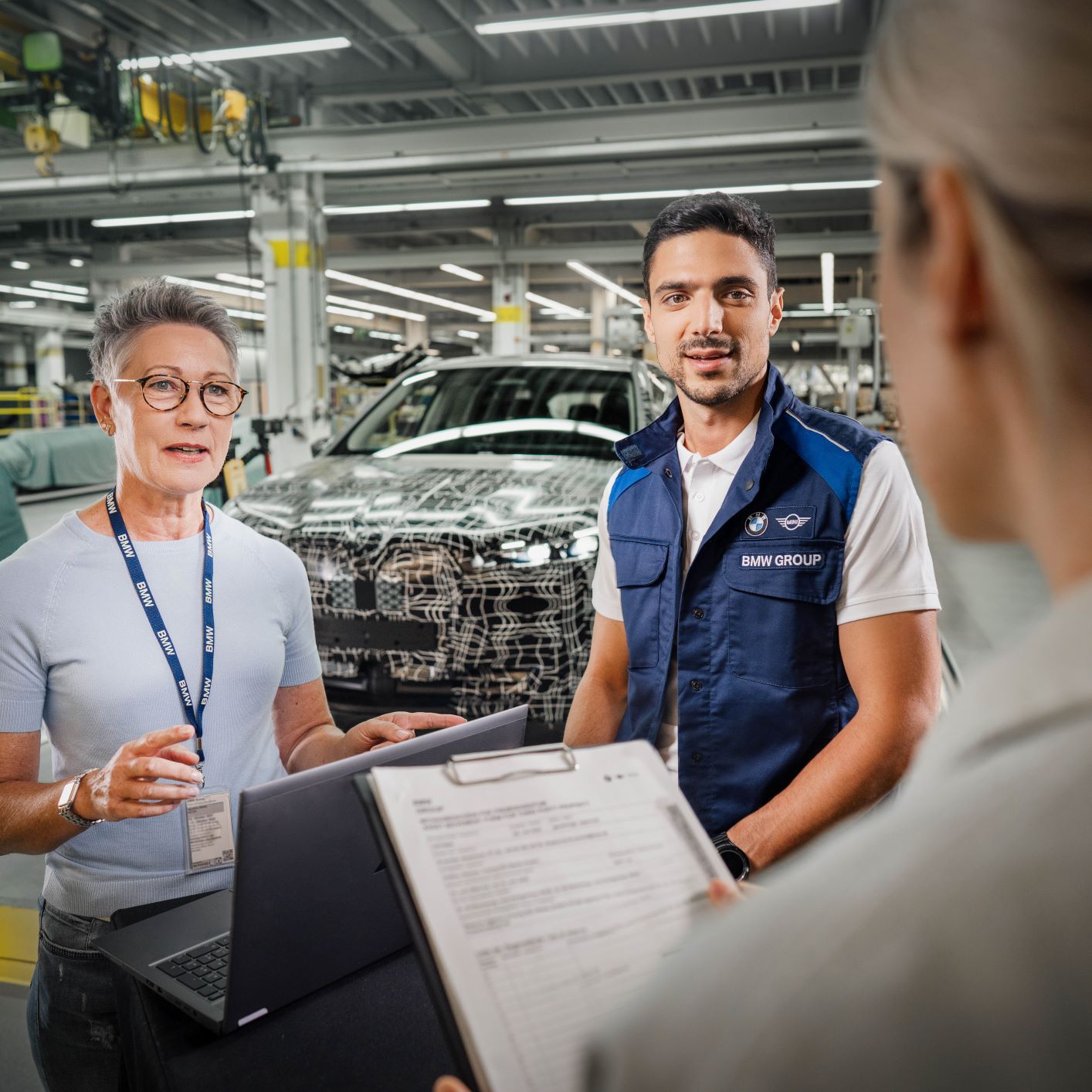 The image shows three engineers having a chat.