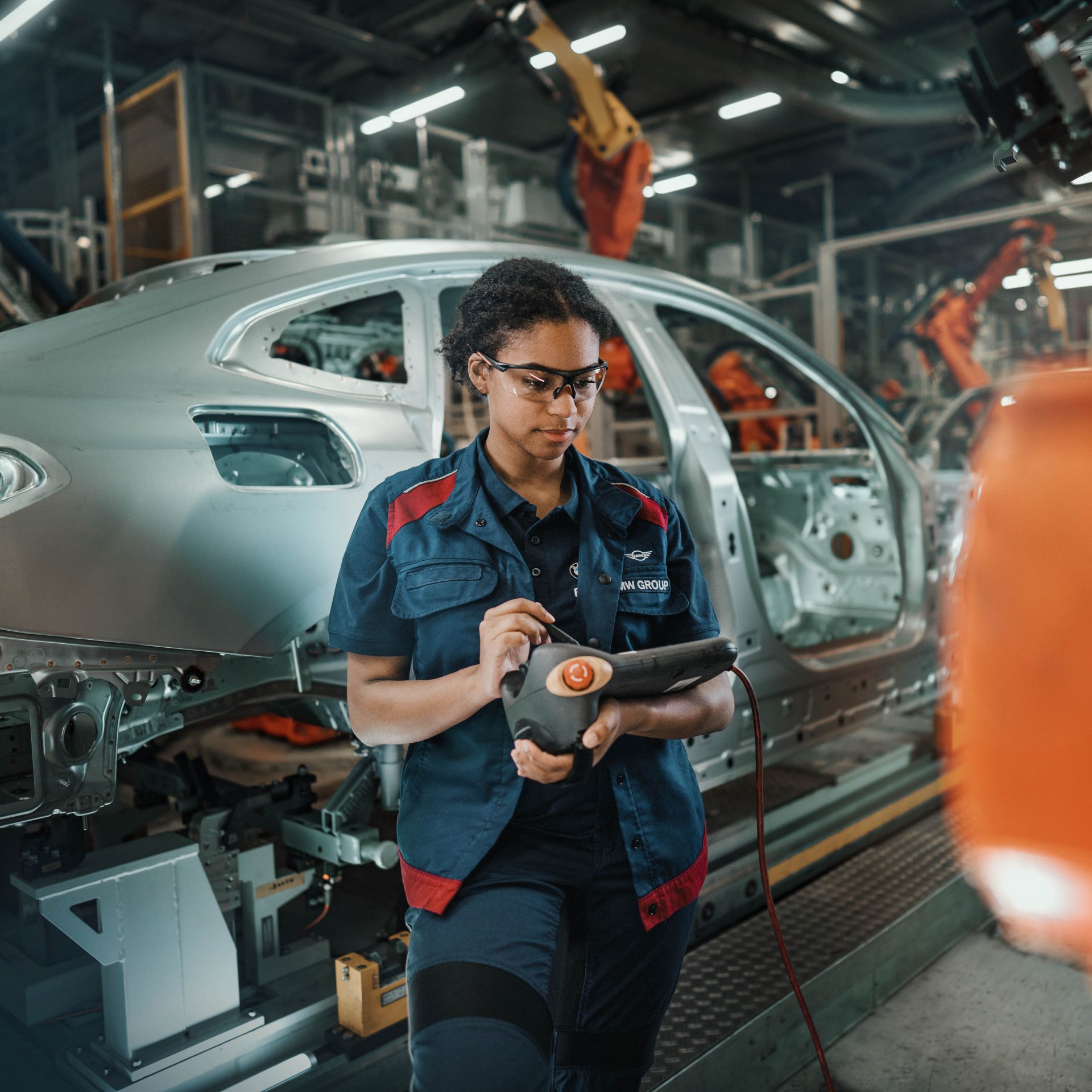 Das Bild zeigt eine BMW Mitarbeiterin bei der Arbeit in der Instandhaltung.