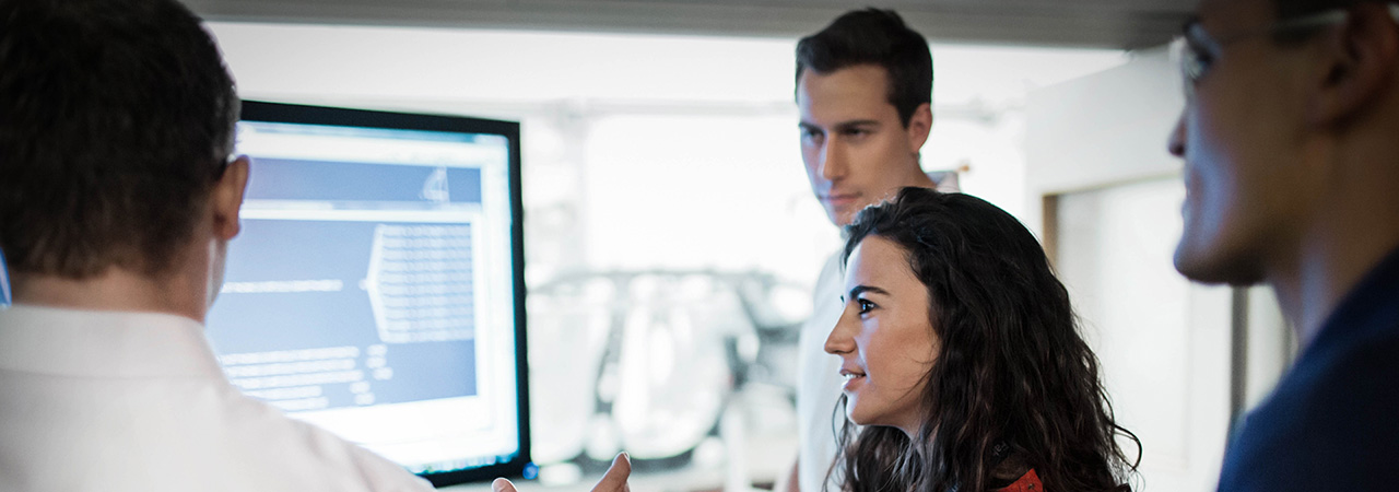 Four colleagues discussing data on a screen