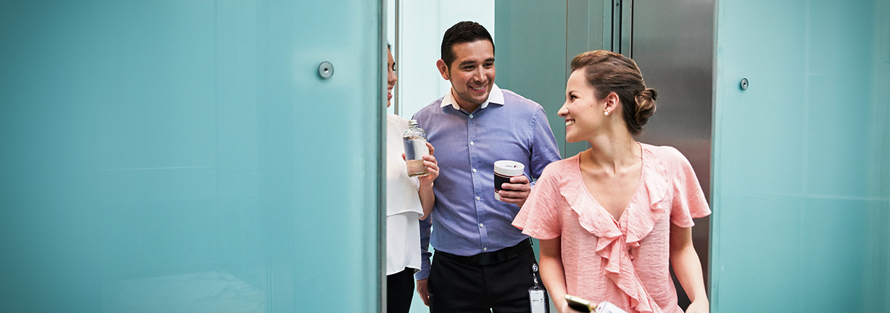 Thre colleagues having a chat in the hallway.