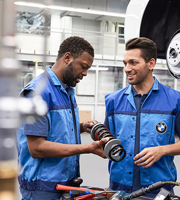 The picture represents the job culture by showing two BMW production employees.