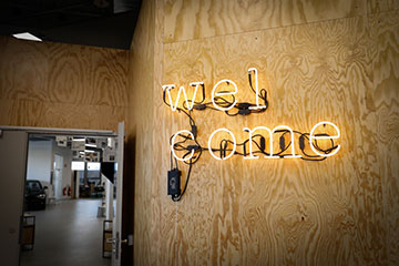 A foto mostra o letreiro de néon "bem-vindo" pendurado em uma parede no Laboratório de Inovação em Munique.