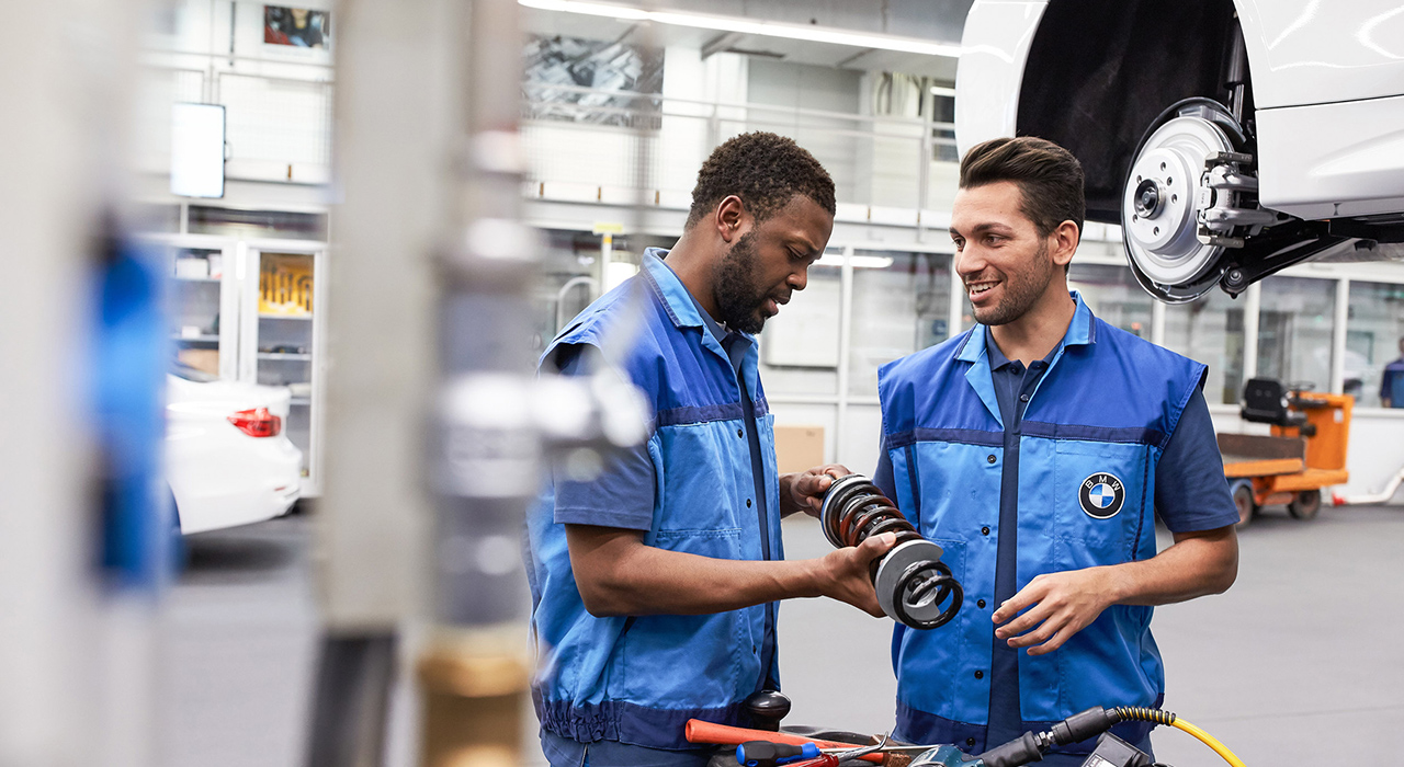 A imagem representa a cultura do trabalho, mostrando dois funcionários da produção da BMW.