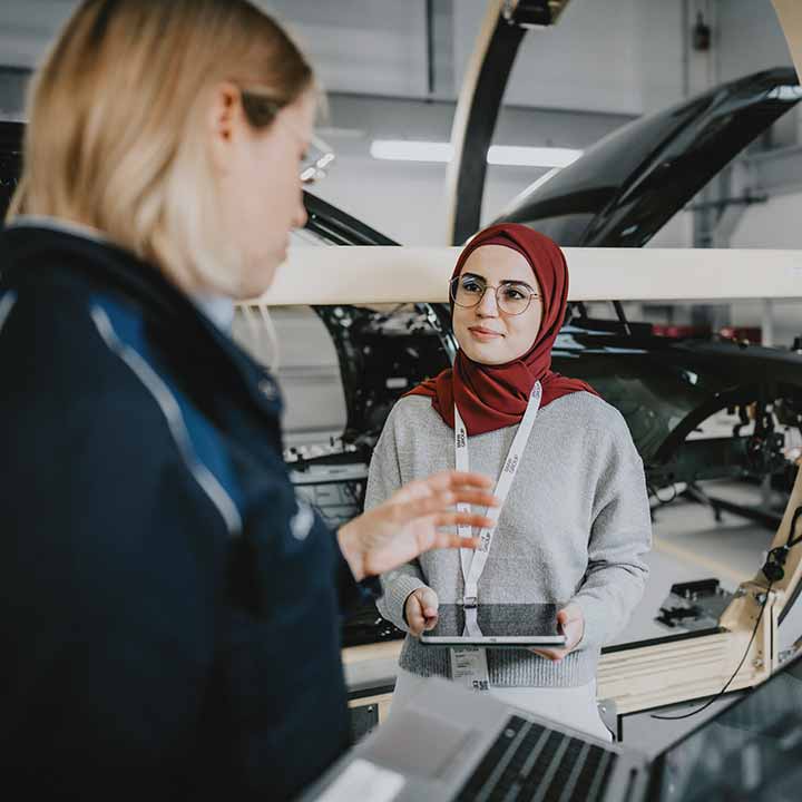 Eine Praktikantin unterhält sich mit ihrer Mentorin bei der BMW Group.