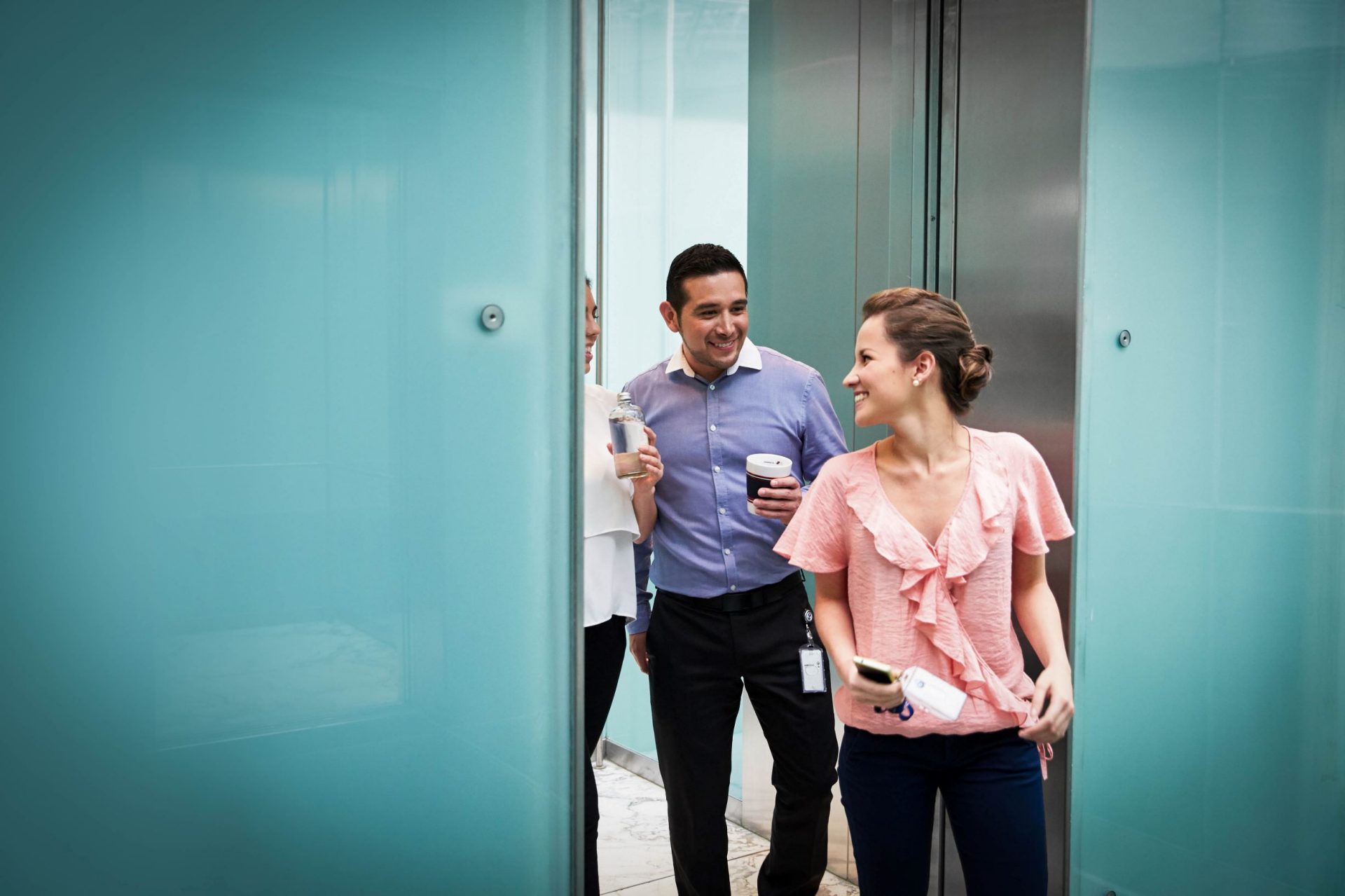 Three colleagues having a conversation while walking through their office.