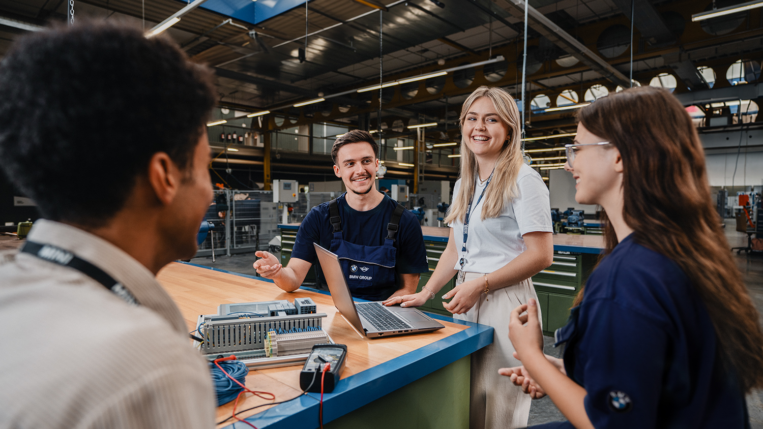 Four apprentices having a chat in the workshop