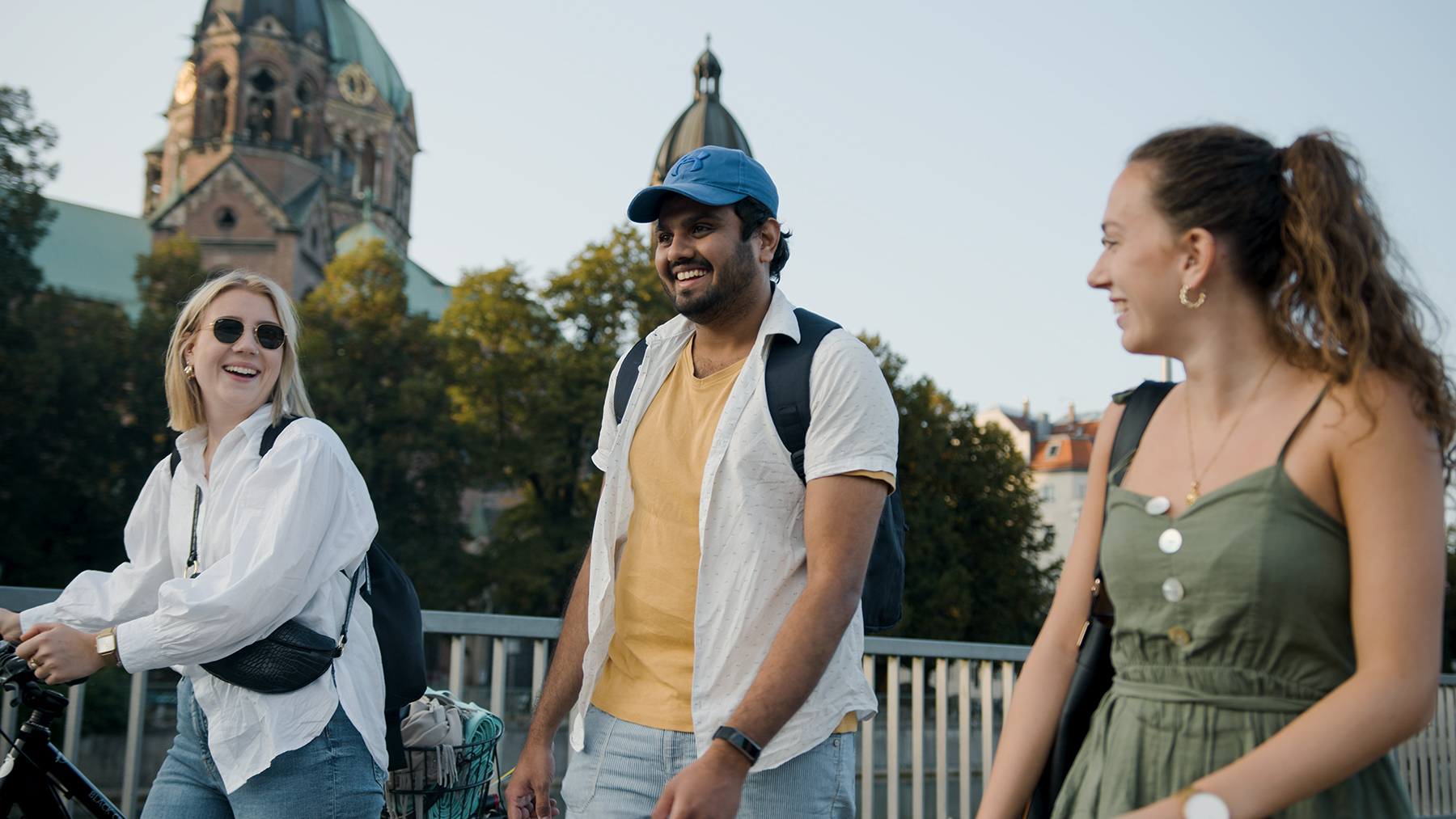 Drei Kolleg:innen spazieren an der Isar in München