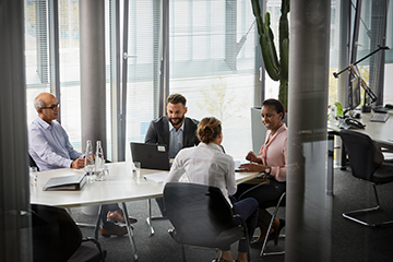 Employees in Legal Services, IP and Compliance sitting together in a Meeting.