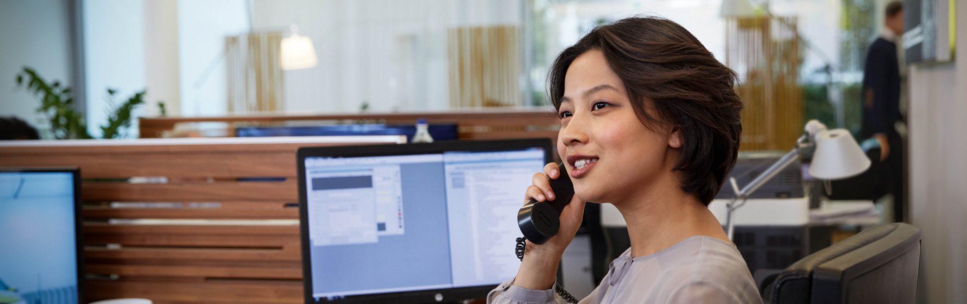 BMW employee providing customer service related to construction and services, seated at a desk.