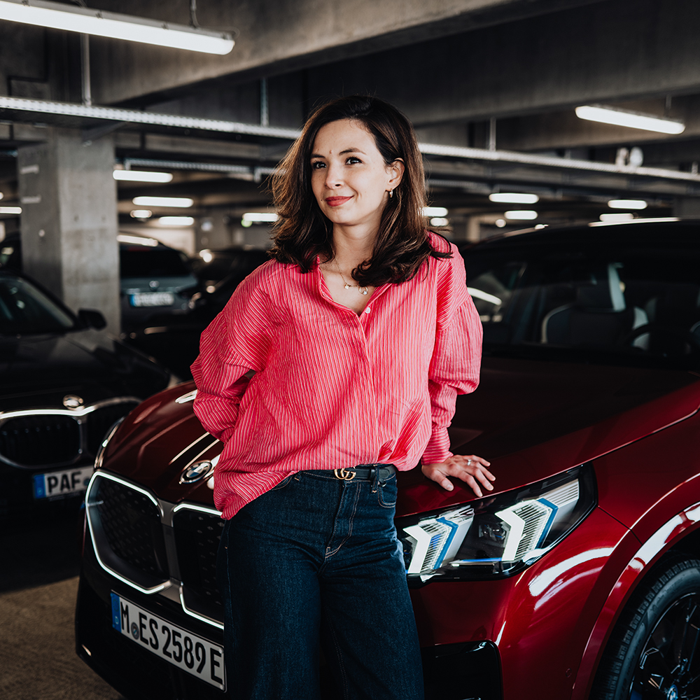 BMW Data Hub Specialist Denise in front of a red BMW X2