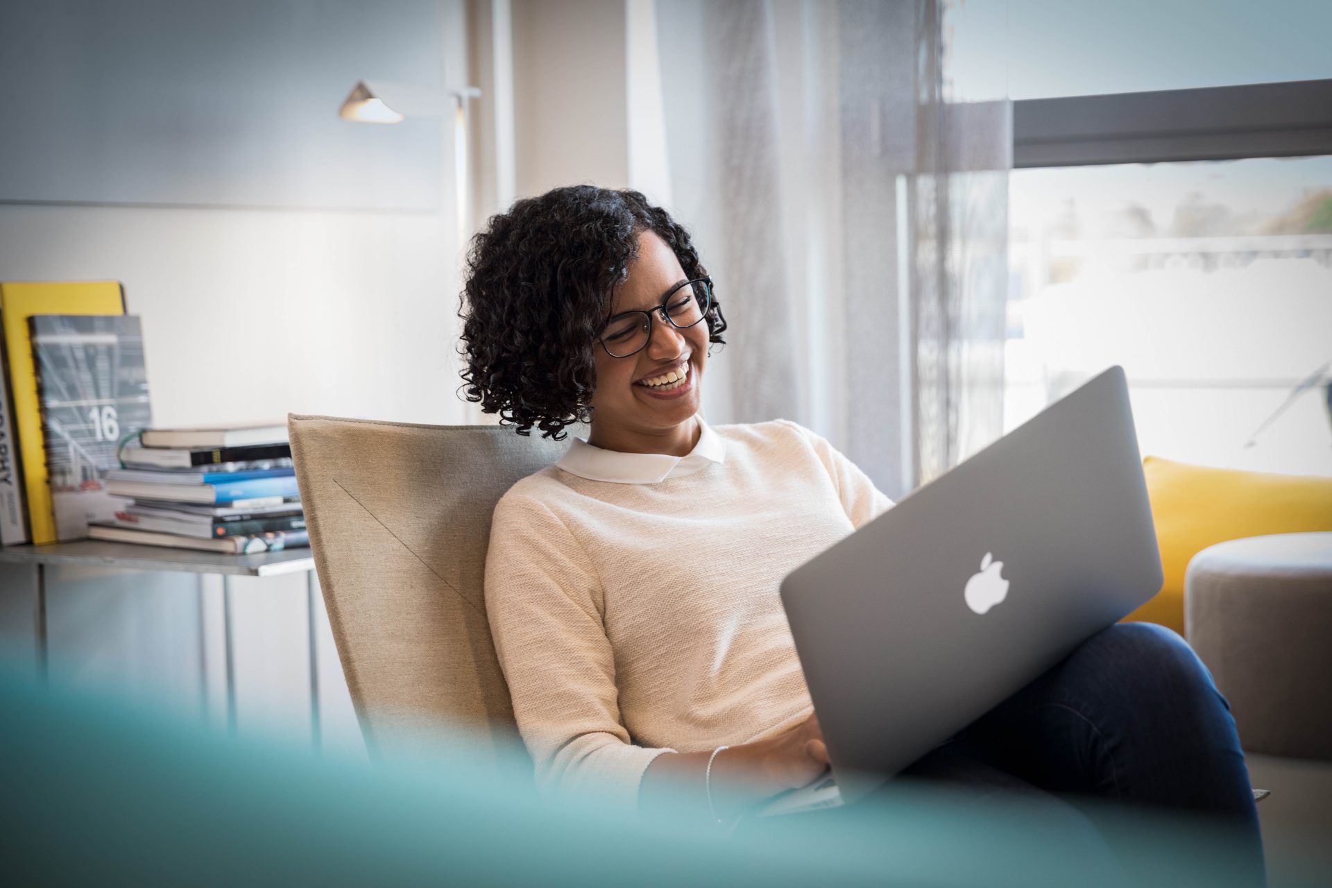 A BMW employee working on her computer, laughing.