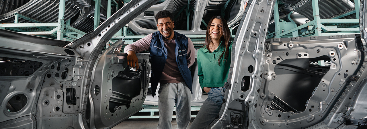 The photo shows three apprentices in a BMW work shop.