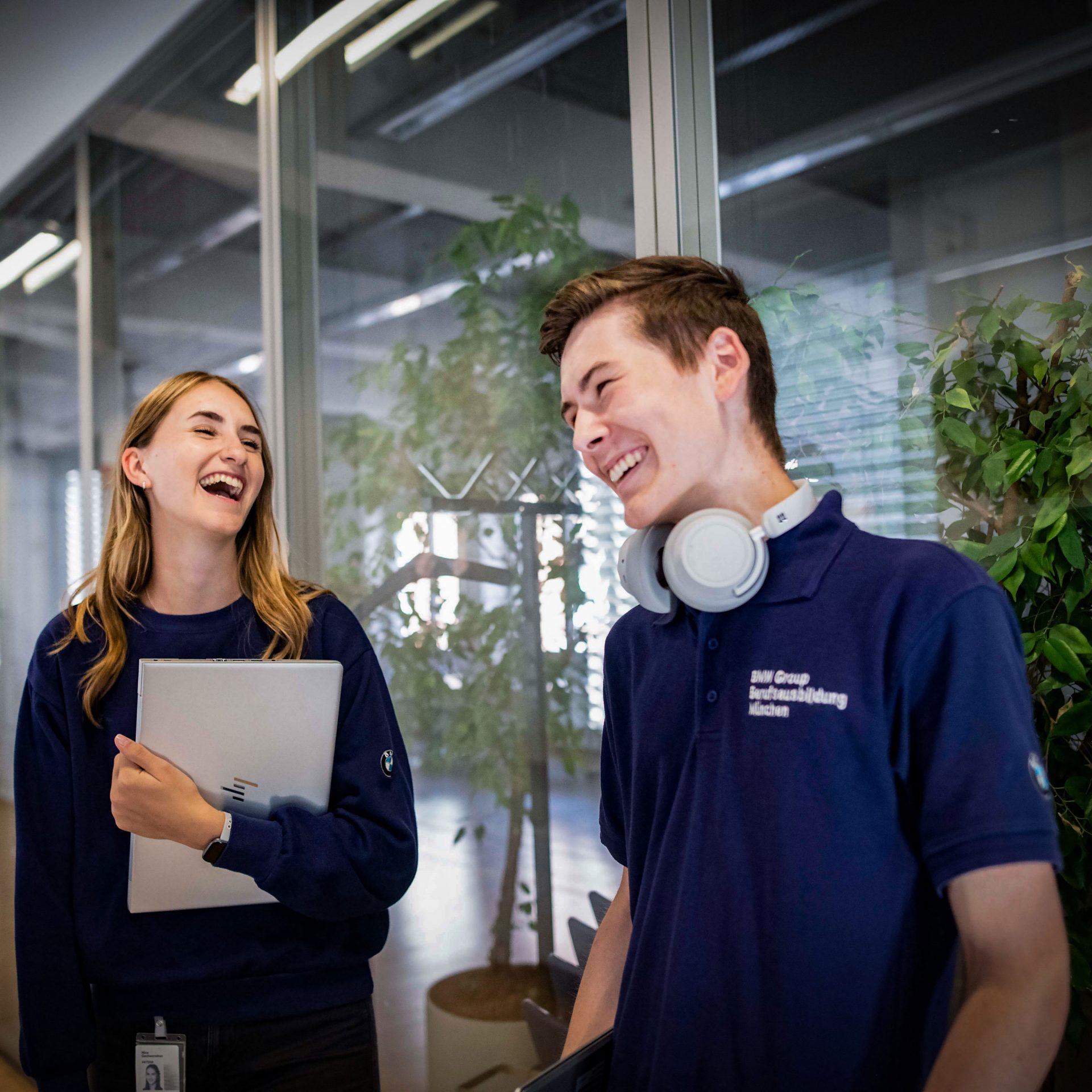 The image shows two apprentices in an office environment.