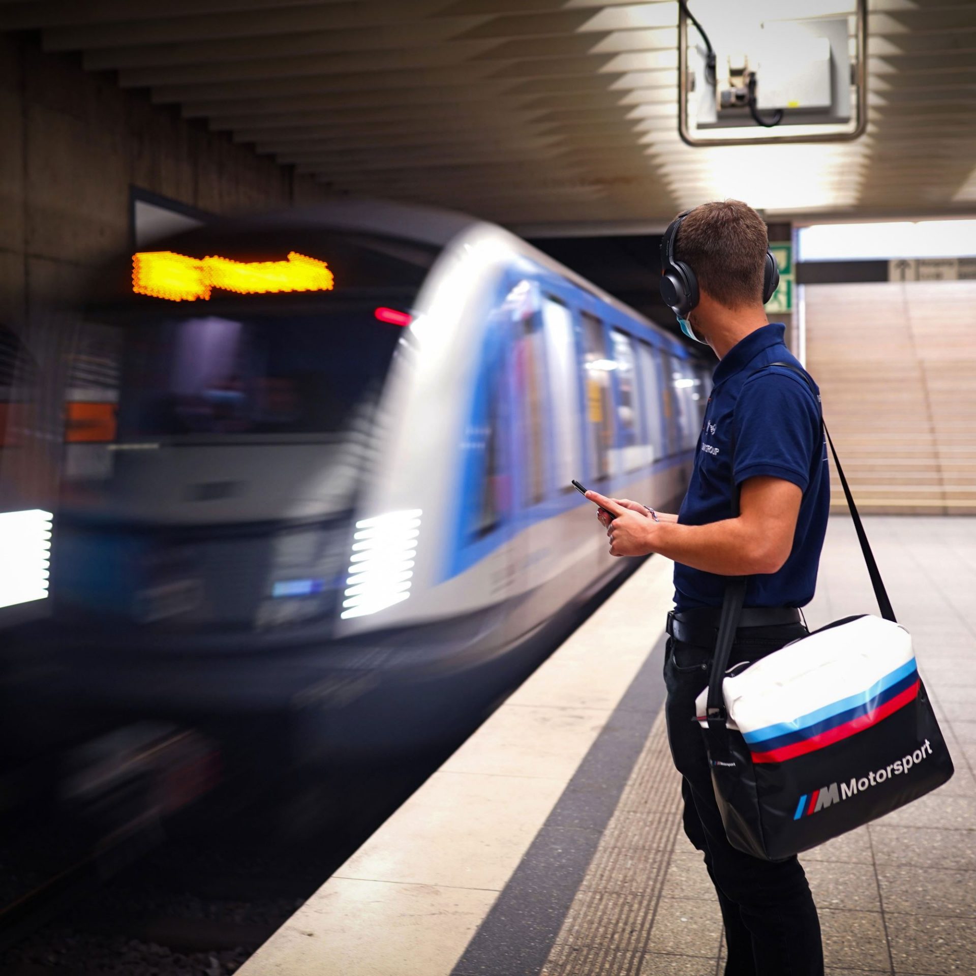 The image shows a BMW apprentice waiting for the tube to arrive.