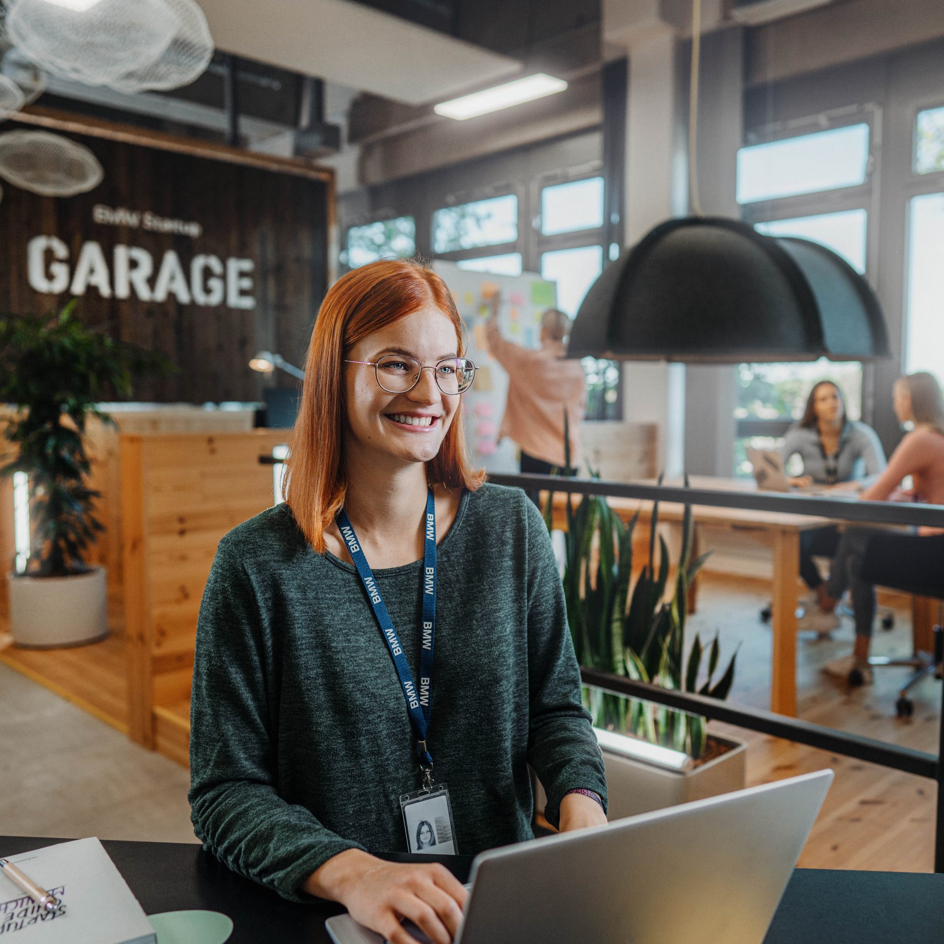 The picture shows a young BMW employee at work.