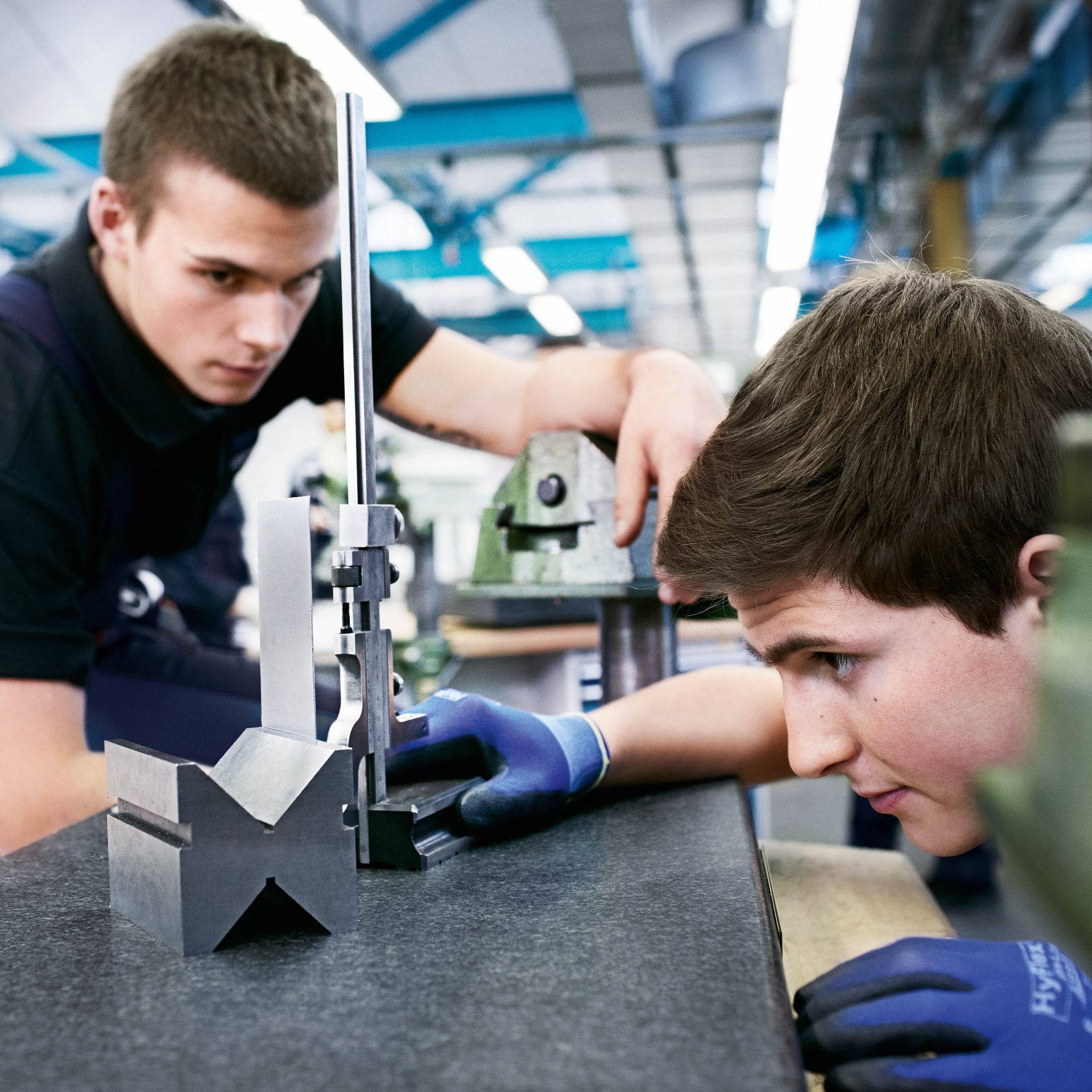 The picture shows two apprentices doing a task during their apprenticeship.
