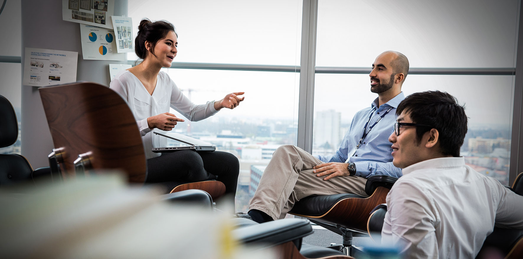 A Student and two BMW employees are sitting together and have a conversation.