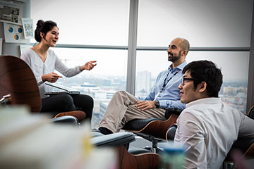 Two BMW Group employees are talking to a Student.