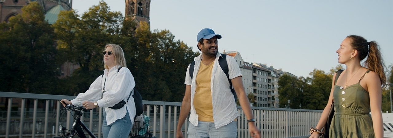 Das Foto zeigt drei lachende BMW Mitarbeiter bei einem Spaziergang draußen.