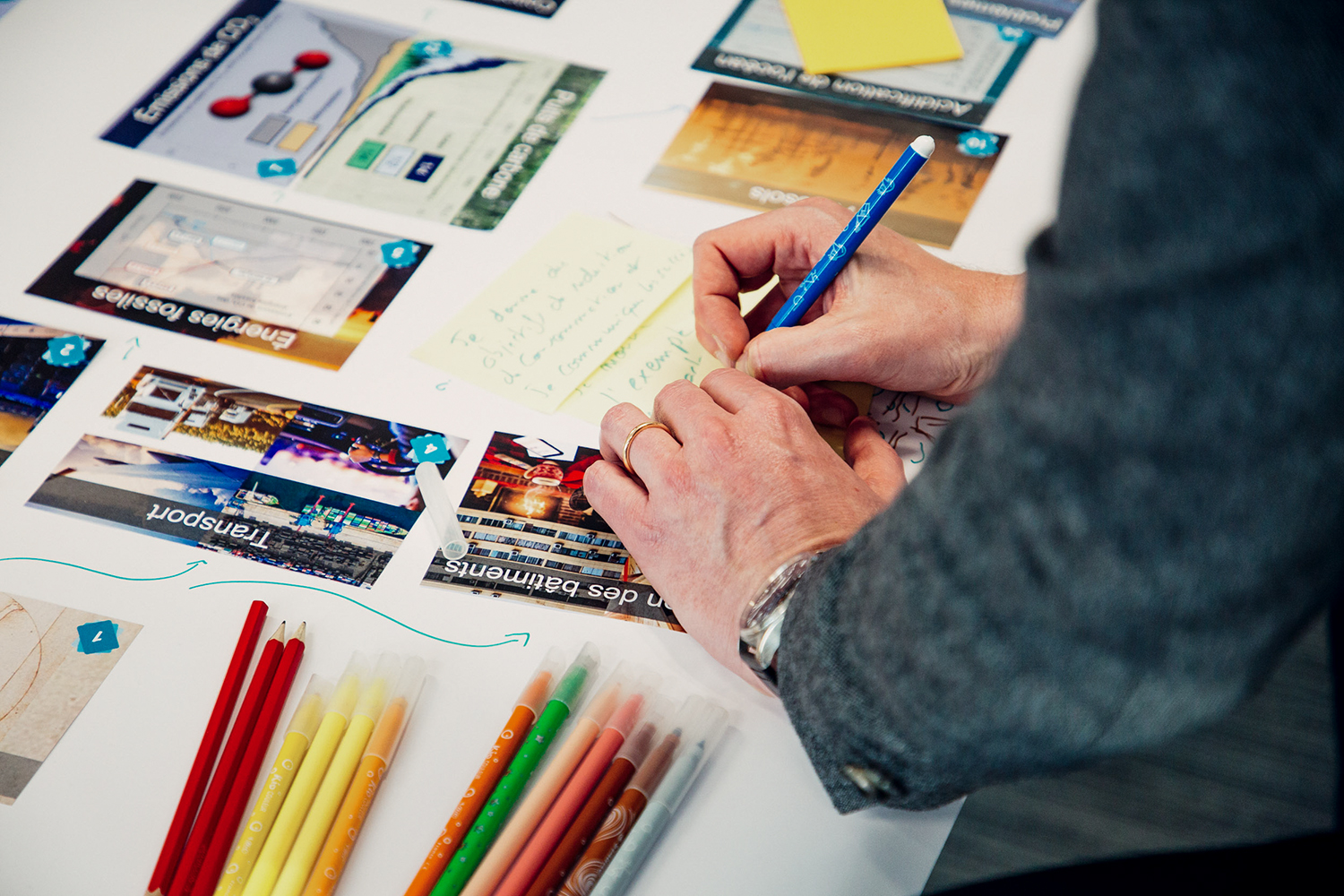 Close-up of a person's hands writing on cards with a pen