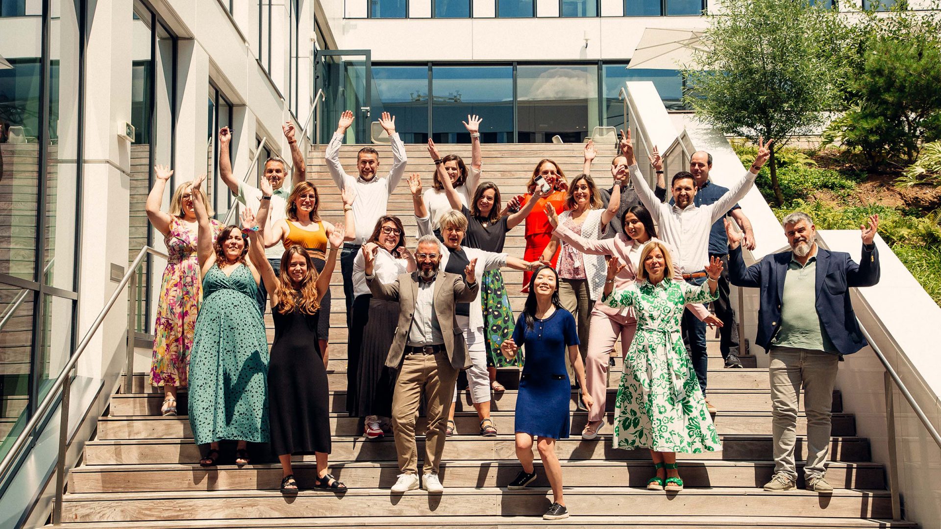 Group picture of a team event in France, many colleagues waving and smiling