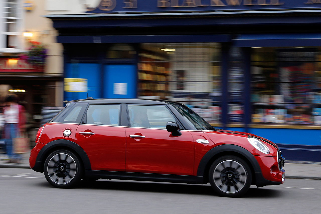 A red MINI driving on the street