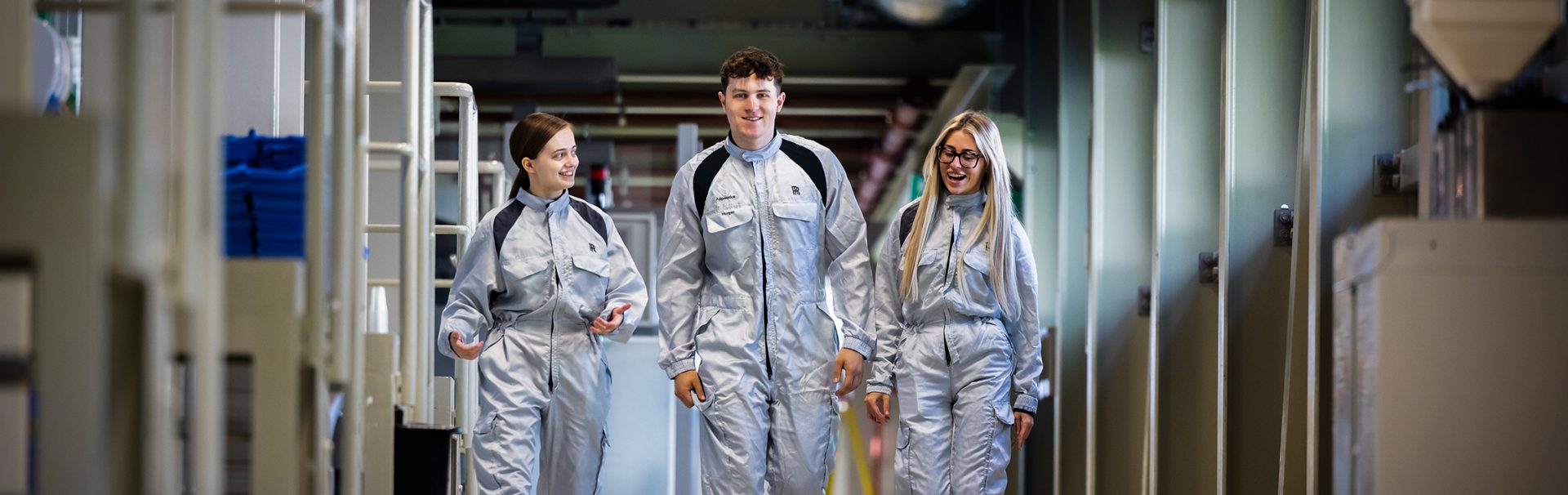 Three apprentices walking along the production hall of Rolls-Royce Motorcars