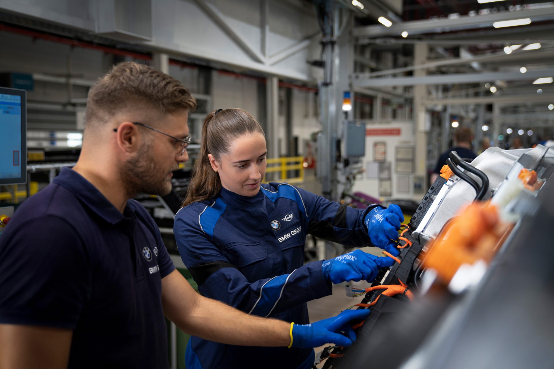 A BMW Group technical apprentice and teacher at work.